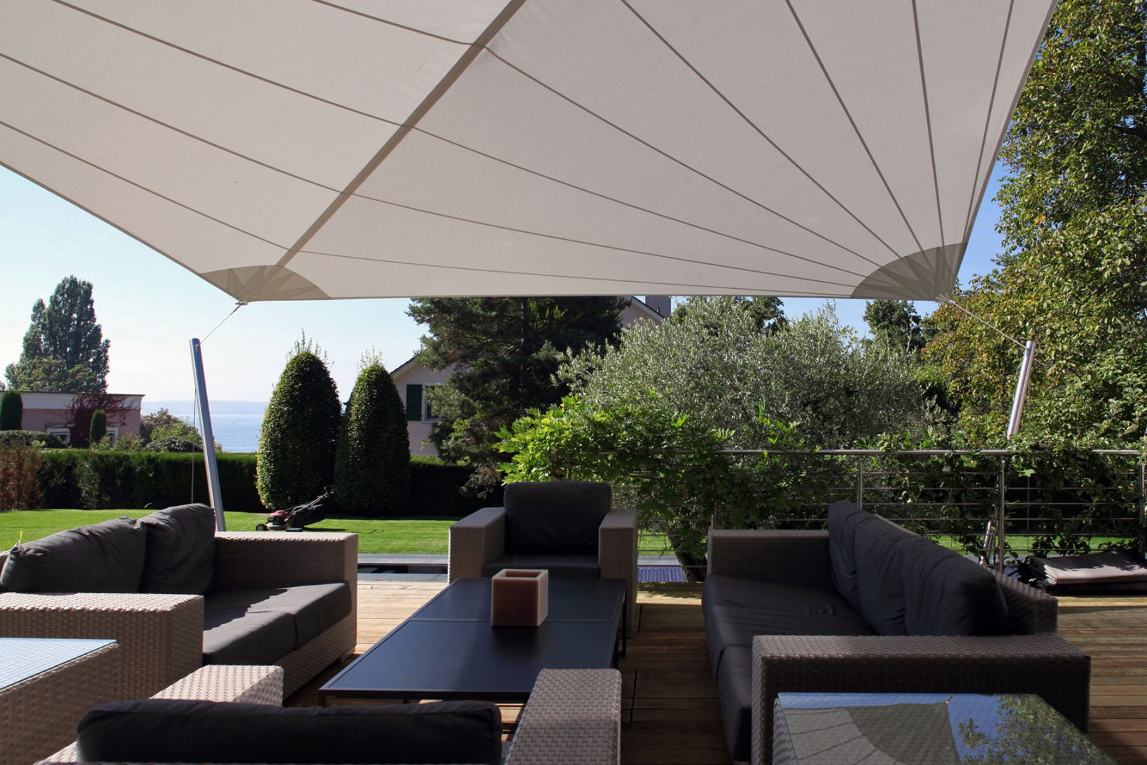 terrasse moderne d'une villa à Anières à Genève avec mobilier et bois teck voiles tendues comme protection solaire