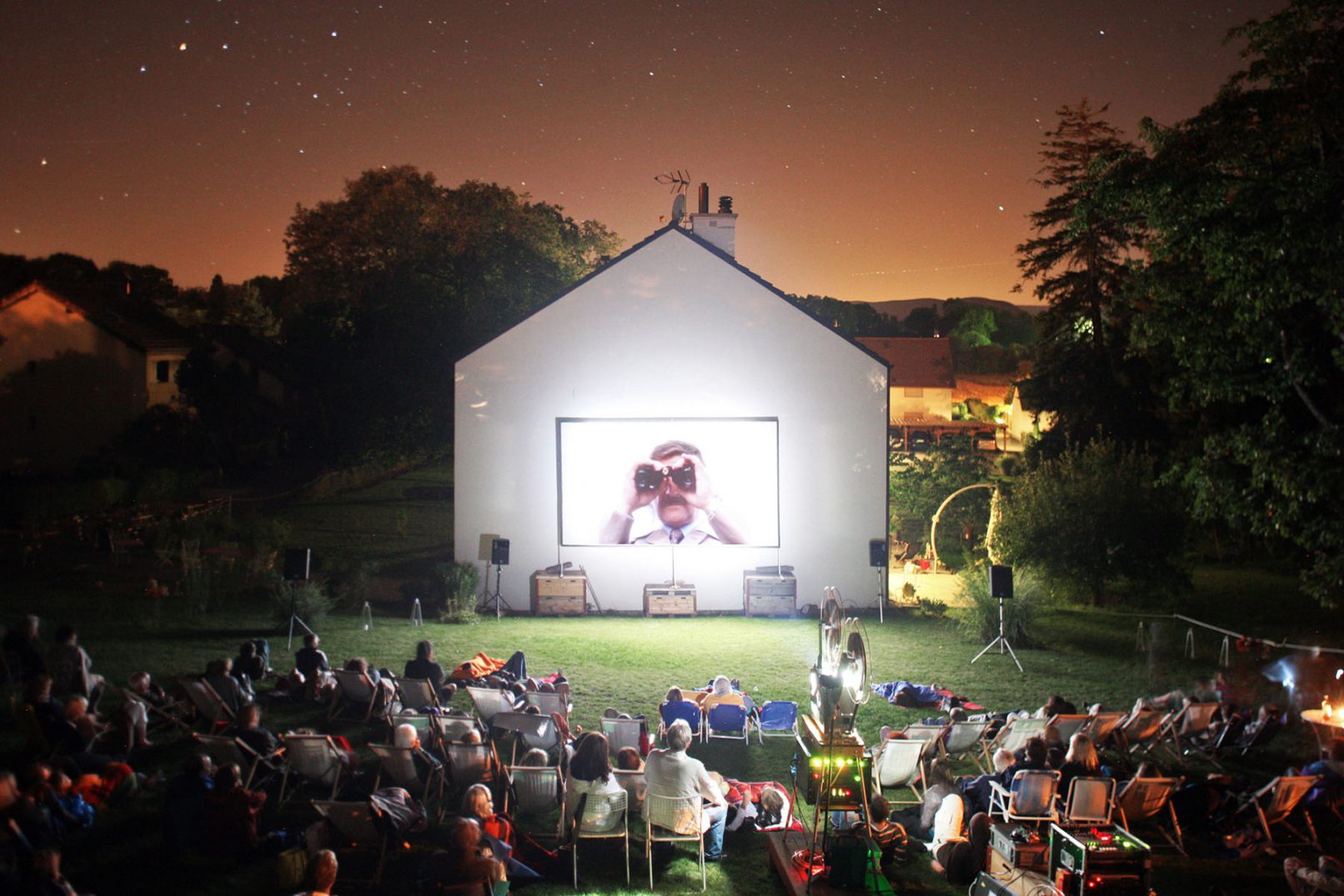 Projection d'un film les Faiseurs de Suisses par road movie sur la façade nord d'une maison à Laconnex Genève