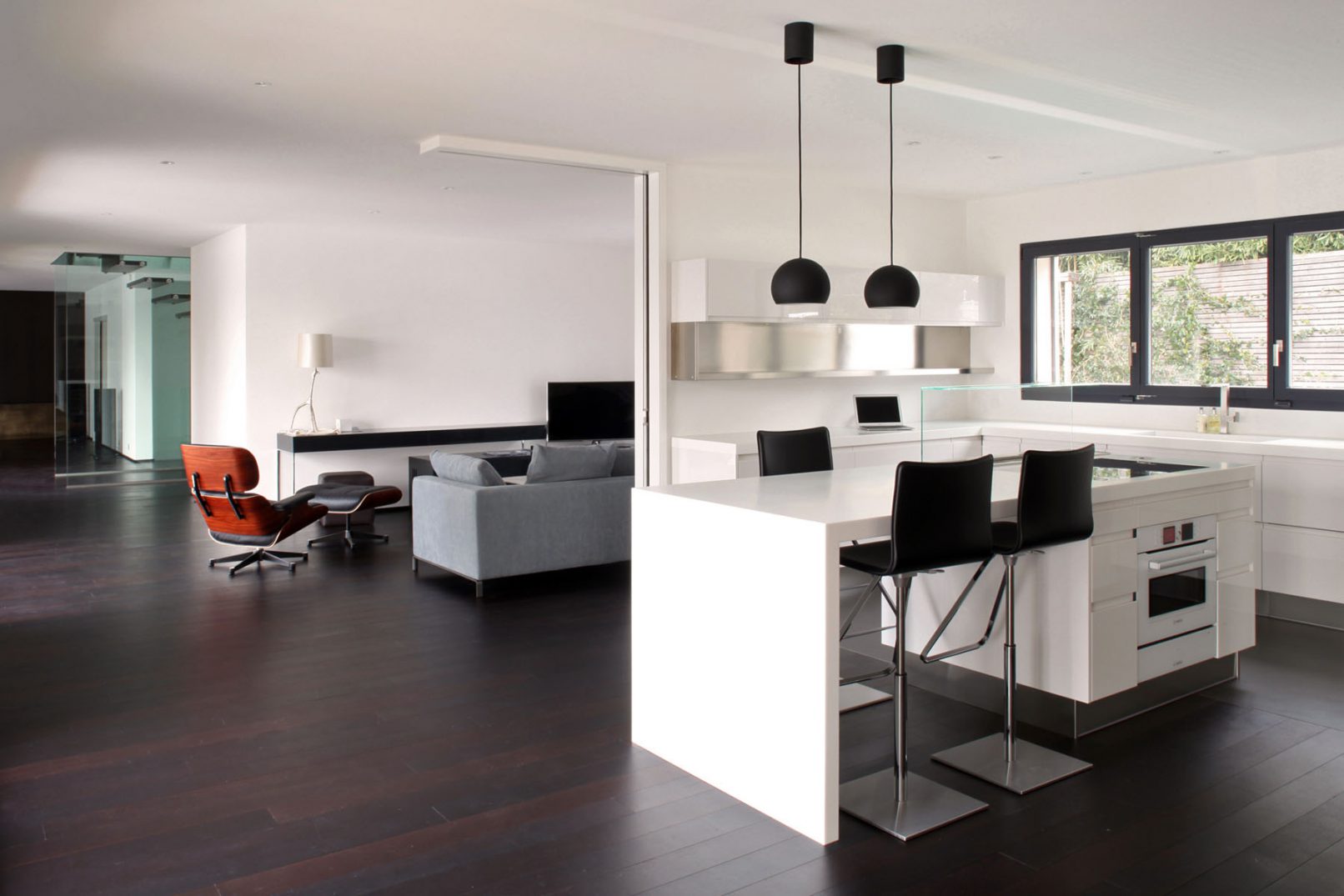 cuisine arclinea blanche dans une villa à Genève avec fauteuil lounge ottoman cuir noir de Charles & Ray Eames
