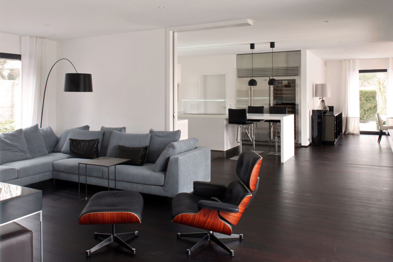 fauteuil lounge ottoman cuir noir de Charles & Ray Eames Vitra avec une cuisine arclinea blanche dans une villa à Genève