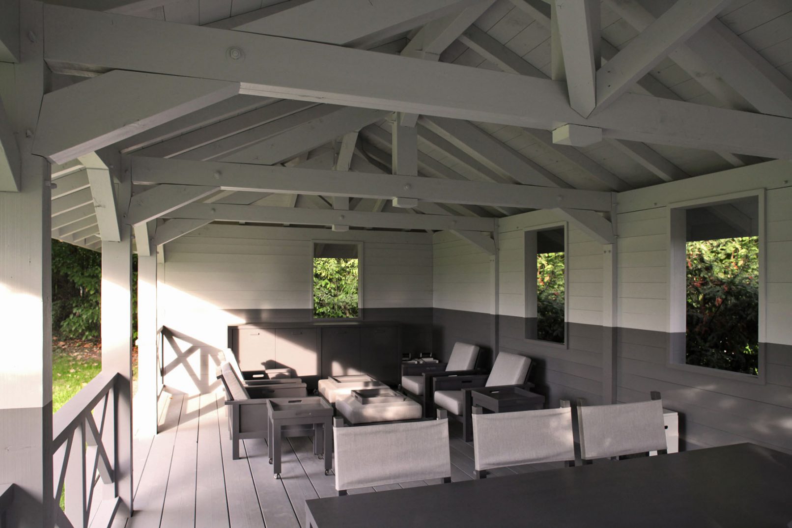 Pavillon d'été avec mobilier de jardin contemporain verdure environnante